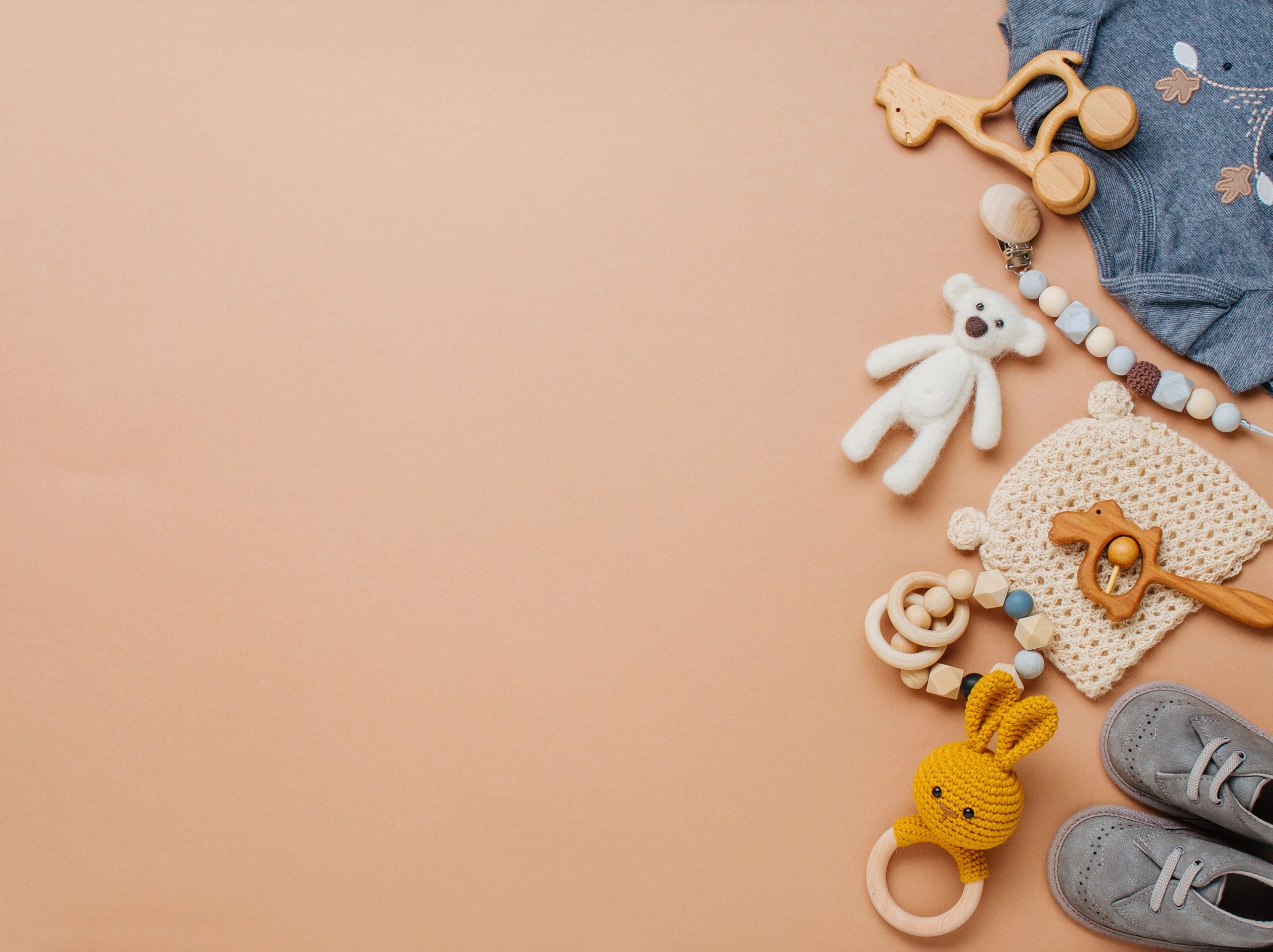 Wooden toys and baby essentials on beige background