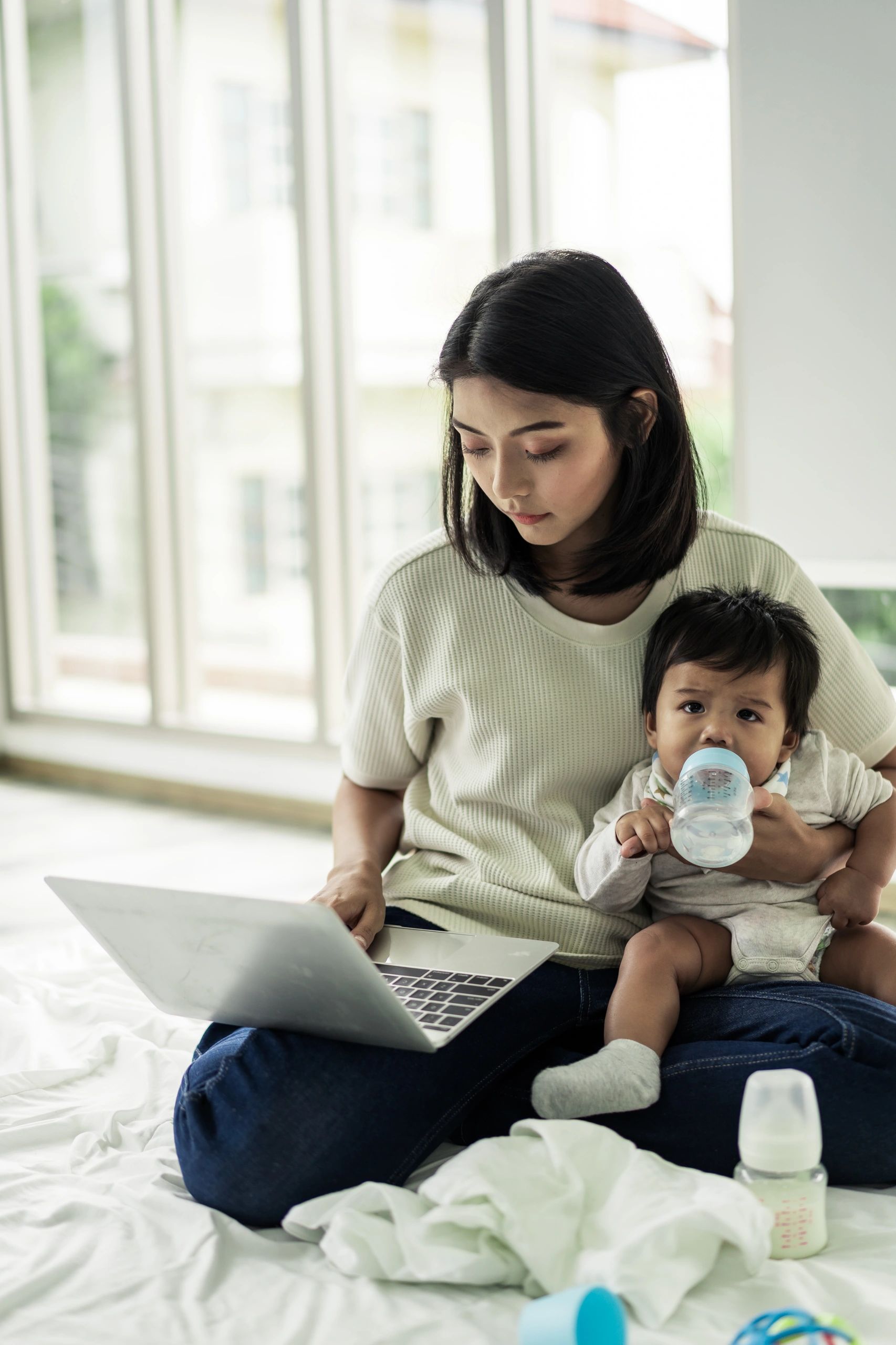 Mother feeding baby with a milk bottle at home
