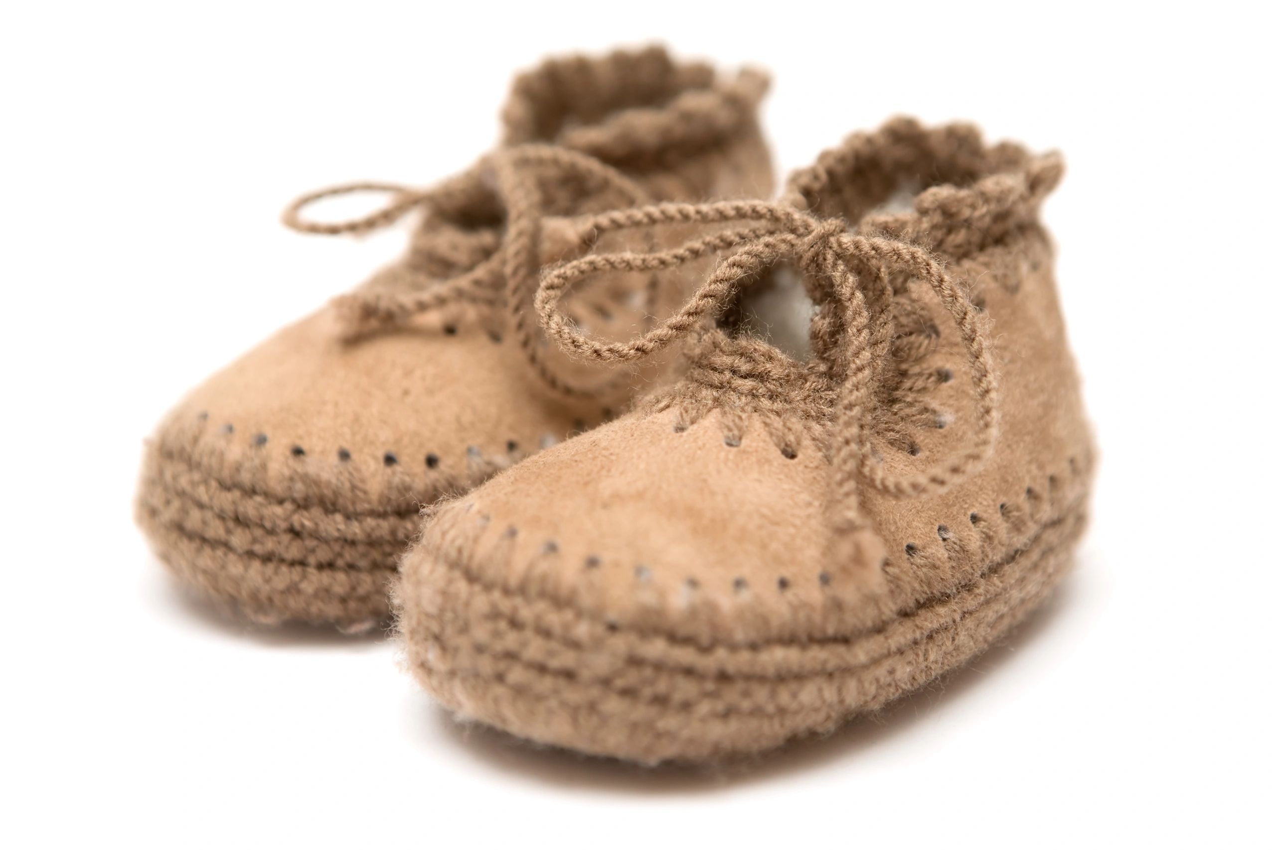 Brown leather baby booties on a white background