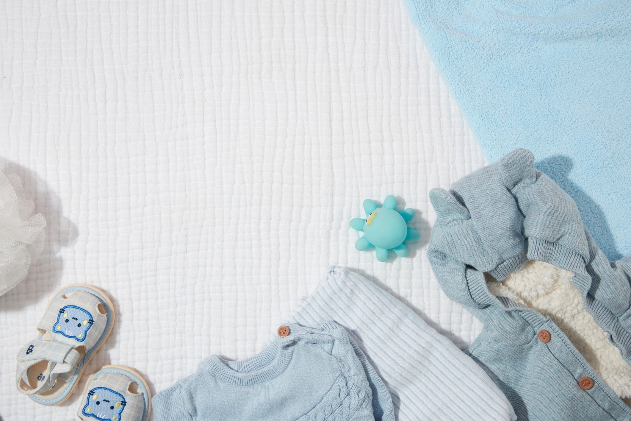 Baby clothing laid out neatly in soft blue tones